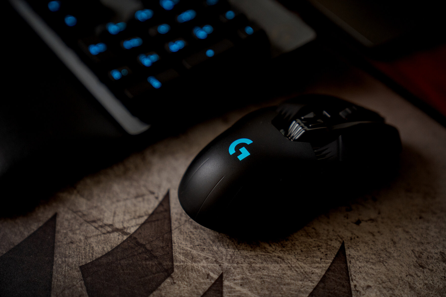 Black Logitech Cordless Computer Mouse on Brown Wooden Table